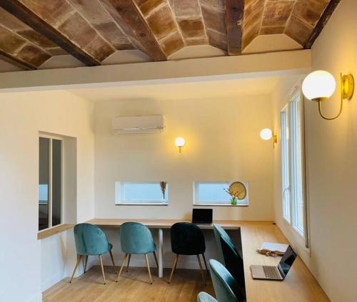 een woonkamer met stoelen en een tafel met een laptop bij La Villa Candau - Cowork & Fun - Piscine - Wifi Fibre in Les Angles Gard