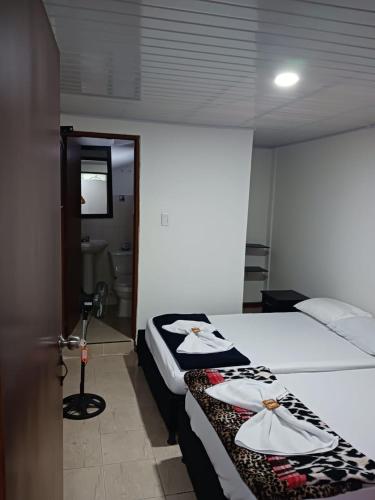 a hotel room with two beds and a mirror at Hotel imperio cafetero in Armenia