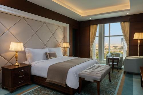 a bedroom with a large bed and a large window at The St. Regis New Capital Cairo in Cairo