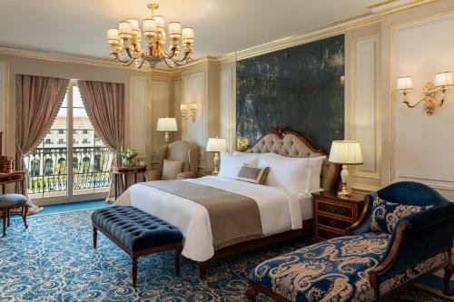 a bedroom with a large bed and a chandelier at The St Regis New Capital Cairo in Cairo
