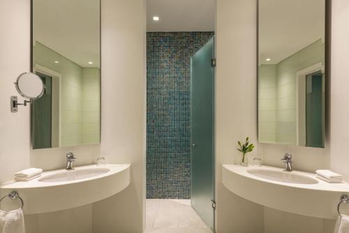 a bathroom with two sinks and two mirrors at The St. Regis New Capital Cairo in Cairo