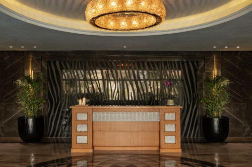 a lobby with a reception desk and a chandelier at The St. Regis New Capital Cairo in Cairo