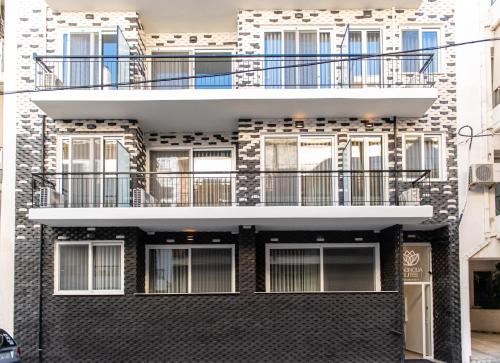 a black brick building with a balcony at MAGNOLIA SUITES in Nafpaktos