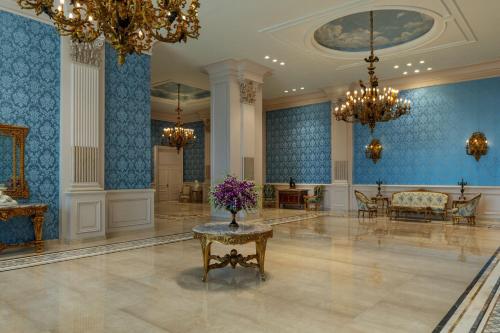 a lobby with blue walls and a table with purple flowers at The St. Regis New Capital Cairo in Cairo