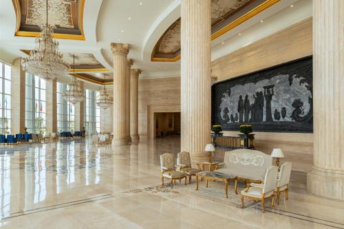 a large lobby with columns and a large painting on the wall at The St. Regis New Capital Cairo in Cairo