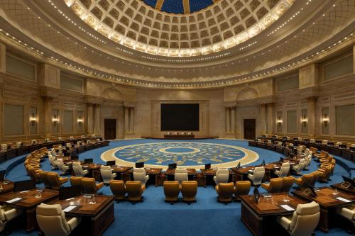 an empty meeting room with a large stage in the middle at The St. Regis New Capital Cairo in Cairo