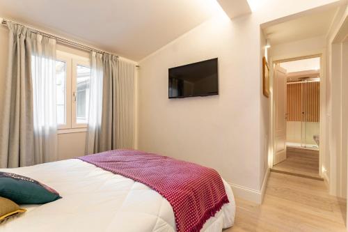 a bedroom with a bed and a tv on the wall at Art Apartment Luxury Sofia Suite in Florence