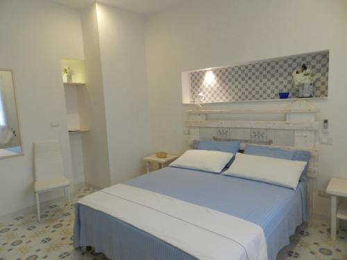 a bedroom with a blue and white bed with two pillows at A Pochi Metri Dal Mare in Marina di Mancaversa