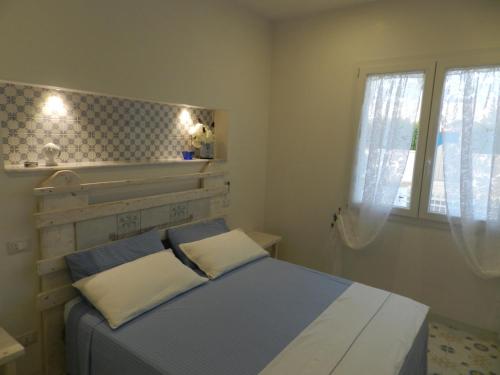 a small bedroom with a bed and a window at A Pochi Metri Dal Mare in Marina di Mancaversa