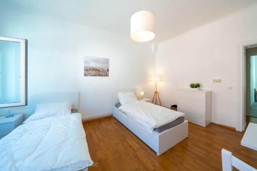 a white room with two beds and a window at Apt Watt 2 Zimmer 55qm TV Waschmaschine Trockner Vollausstattung zentral in Fürstenwalde