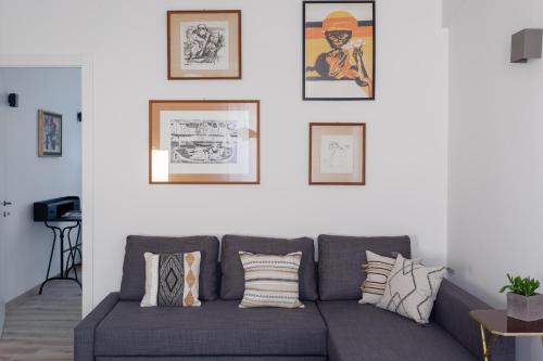 a living room with a gray couch and pictures on the wall at Olimpico Apartment - Zen Real Estate in Rome
