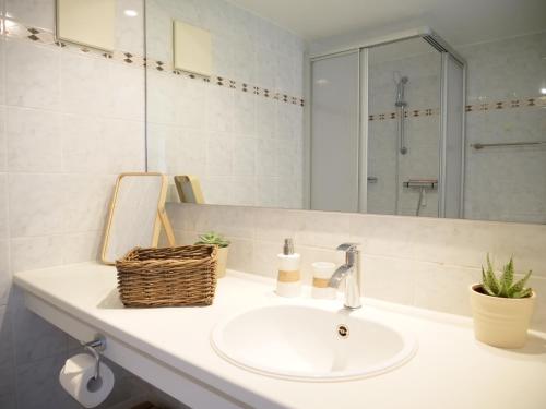 a white bathroom with a sink and a mirror at Oceanblue Appartements - Laboe in Laboe