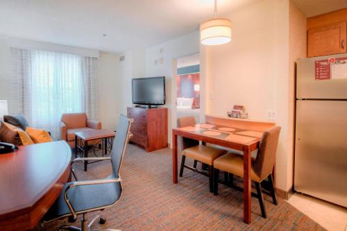 a room with a table and a kitchen with a refrigerator at Residence Inn by Marriott Chapel Hill in Chapel Hill