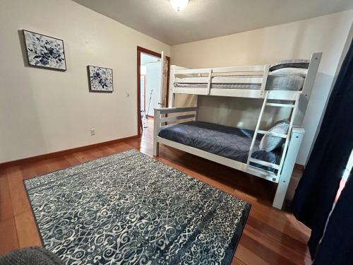 a bedroom with two bunk beds and a rug at Twin Pines Cabin in Wilderness Ranch on Hwy 21, AMAZING Views, 20 ft ceilings, fully fenced yard, pet friendly, , Go paddle boarding at Lucky Peak, or snowshoeing in Idaho City and take in the hot springs, sleeps 10! in Boise