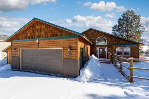 a log home with a garage in the snow at Twin Pines Cabin in Wilderness Ranch on Hwy 21, AMAZING Views, 20 ft ceilings, fully fenced yard, pet friendly, , Go paddle boarding at Lucky Peak, or snowshoeing in Idaho City and take in the hot springs, sleeps 10! in Boise