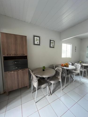 een keuken met 2 tafels en stoelen in een kamer bij Casa do Anjo in Fernando de Noronha