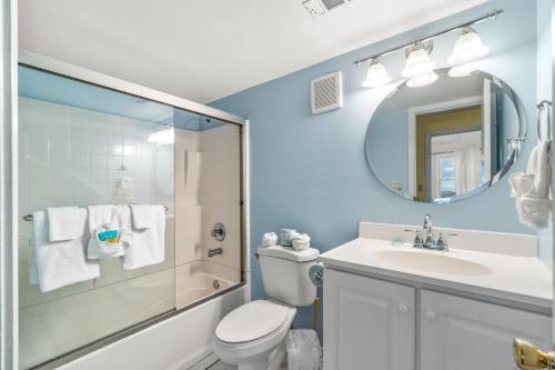 a bathroom with a toilet and a sink and a mirror at The Treehouse On the Bay in Pensacola Beach