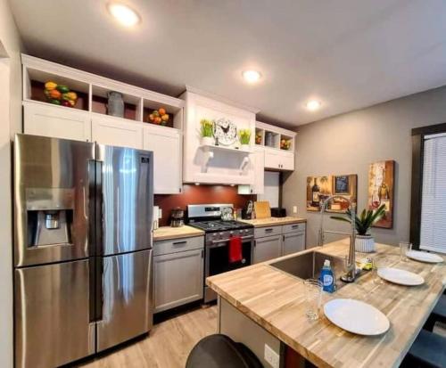 a kitchen with a stainless steel refrigerator and white cabinets at King Bed In Main Floor - Downtown Vacation Rental in Kalamazoo
