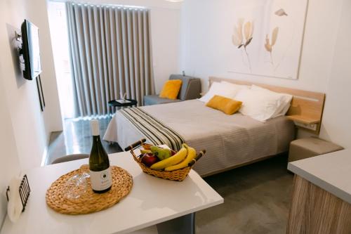 um quarto com uma cama e uma cesta de frutas sobre uma mesa em MAGNOLIA SUITES em Lepanto