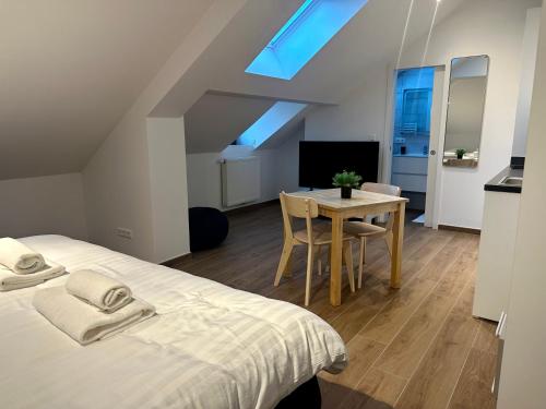 a bedroom with a bed and a table and a tv at IMMOBILIARE Lux Tram in Luxembourg