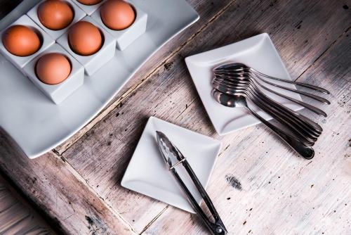 a table with a plate of eggs and utensils at Hotel Moderno in SantʼAntìoco