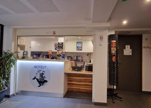 a hotel counter with a man in the background at Hôtel Au Valéry in Sète