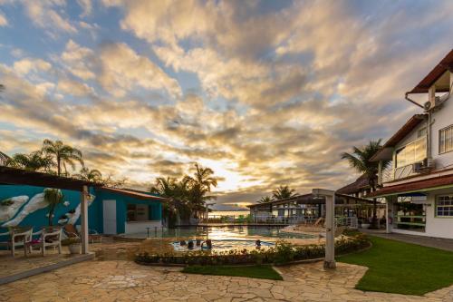 un complejo con una piscina y un cielo nublado en Pousada Daleste en Angra dos Reis