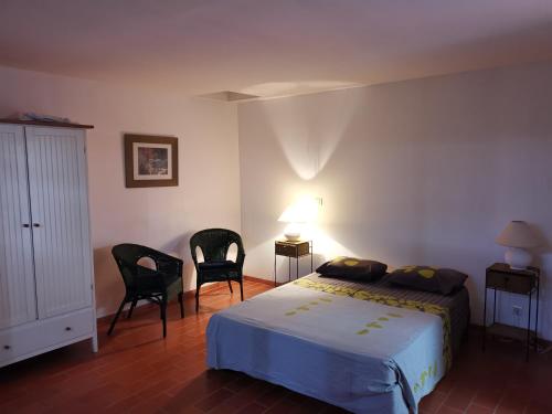1 dormitorio con 1 cama y 2 sillas en Mas des Iscles Mallemort, en Mallemort