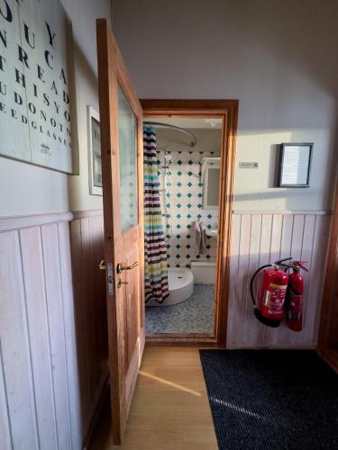 a bathroom with a door leading to a bathroom with a toilet at Gotta Cottages in Selfoss