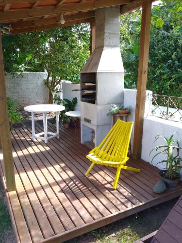 a yellow bench on a wooden deck with a stove at Santinho Hostel in Florianópolis
