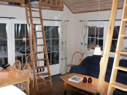 sala de estar con escalera, mesa y sillas en Holzhaus mit überdachter Terrasse, 