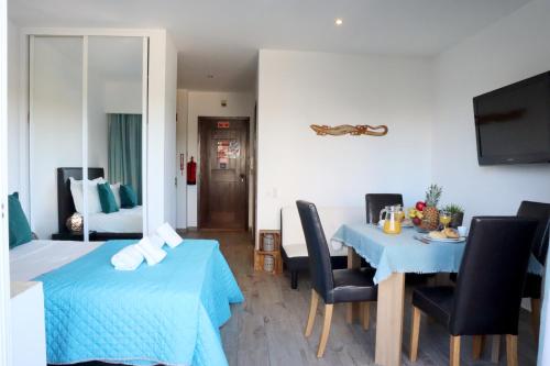 una habitación con mesa y sillas y un dormitorio en Alvor Studio 206, en Alvor