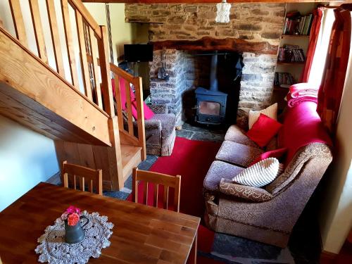 a living room with a couch and a table and a fireplace at Eco Cottage Joe the Buck in Craven Arms