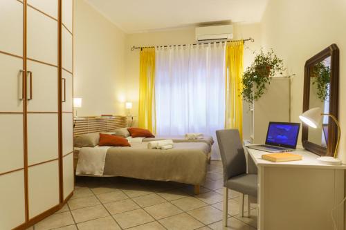 Schlafzimmer mit einem Bett und einem Schreibtisch mit einem Laptop in der Unterkunft Apartment Il Tettuccio di Valerio in Rom
