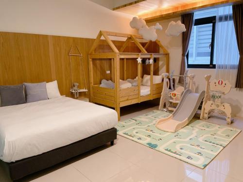 a bedroom with a bed and a crib with two babies at Kenting Dio Inn in Hengchun