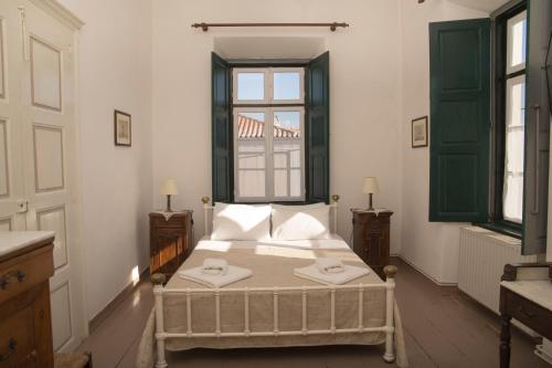 1 dormitorio con cama y ventana en 1861 Mansion Spetses, en Spetses