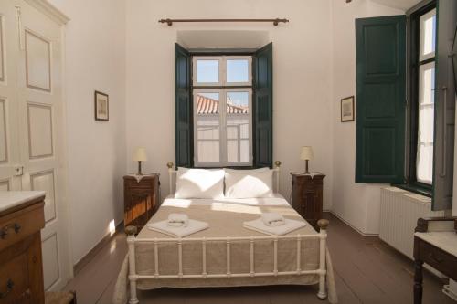 une chambre avec un lit et une fenêtre dans l'établissement 1861 Mansion Spetses, à Spetses