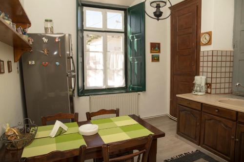 una cucina con tavolo, frigorifero e lavandino di 1861 Mansion Spetses a Spetses