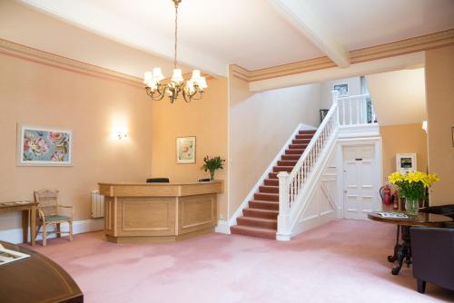 a living room with a staircase and a chandelier at Kingswear Park Club in Kingswear