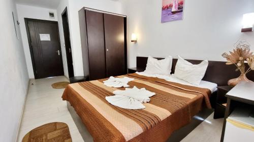een hotelkamer met een bed met handdoeken erop bij Hotel Azur in Eforie Nord