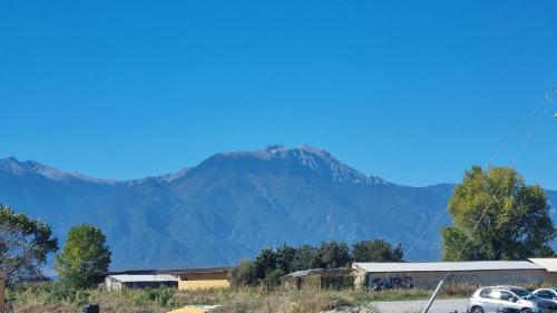 a mountain in the distance with cars parked in front at Dennis Apartment in Olympiaki Akti