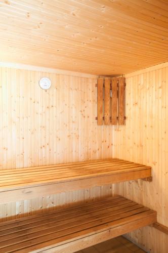 a wooden sauna with a wooden bench in it at Kingswear Park Club with Swimming Pool & Spa in Kingswear