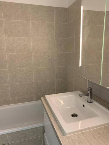 ein Badezimmer mit Waschbecken und Badewanne in der Unterkunft Appartement moderne et spacieux proche Paris in Alfortville