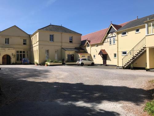 a building with a car parked in a driveway at Kingswear Park Club with Swimming Pool & Spa in Kingswear