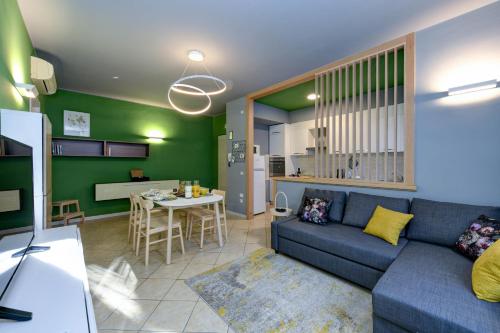 sala de estar con sofá azul y cocina en DesenzanoLoft Green, en Desenzano del Garda