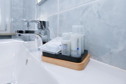 lavamanos en el baño con 2 botellas de jabón en un soporte en DesenzanoLoft Green, en Desenzano del Garda