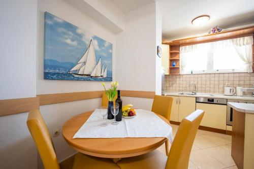 uma cozinha e sala de jantar com uma mesa e uma pintura de veleiro em Apartment Suzy em Zadar