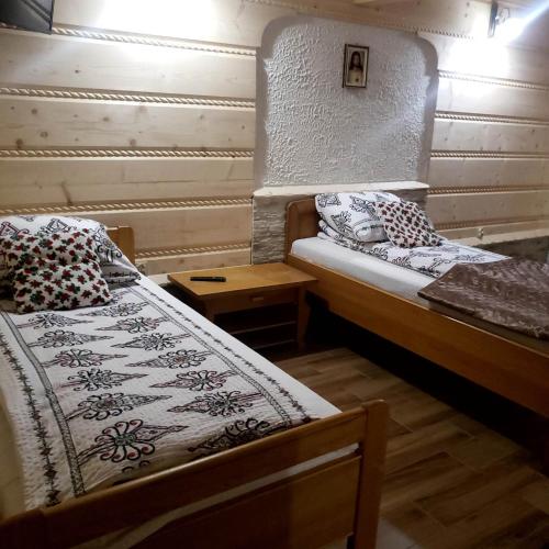 a small room with two beds and a table at U Huraja in Groń