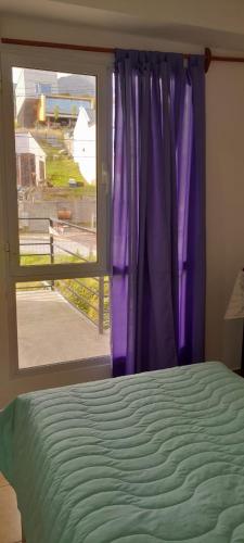 1 dormitorio con cama y ventana con vistas en MyR alojamientos 2 en Ushuaia