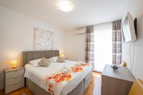 um quarto com uma cama e uma televisão em Apartment Suzy em Zadar